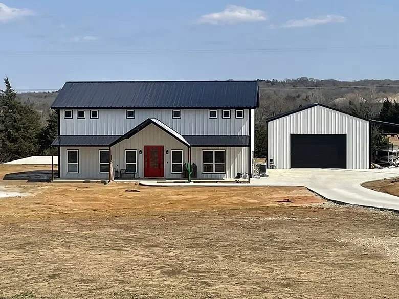 Poured concrete driveway and apron for modern farmhouse with metal roof and white siding