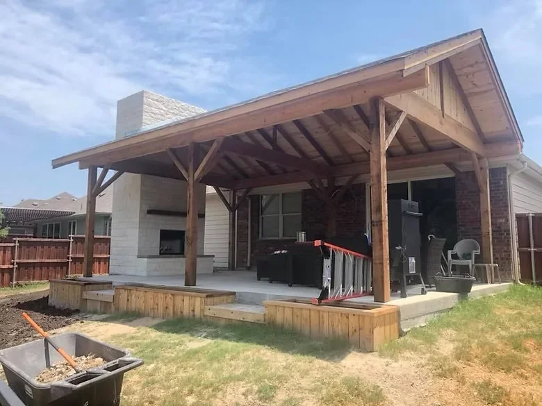 Concrete patio with timber pergola, wooden deck steps, and beam construction