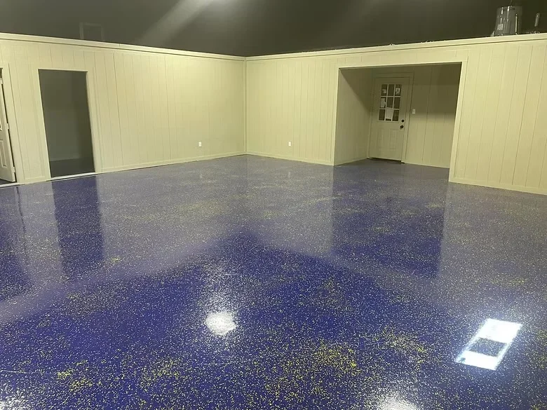 Deep blue epoxy garage floor with metallic gold and silver sparkle aggregate, high-gloss finish