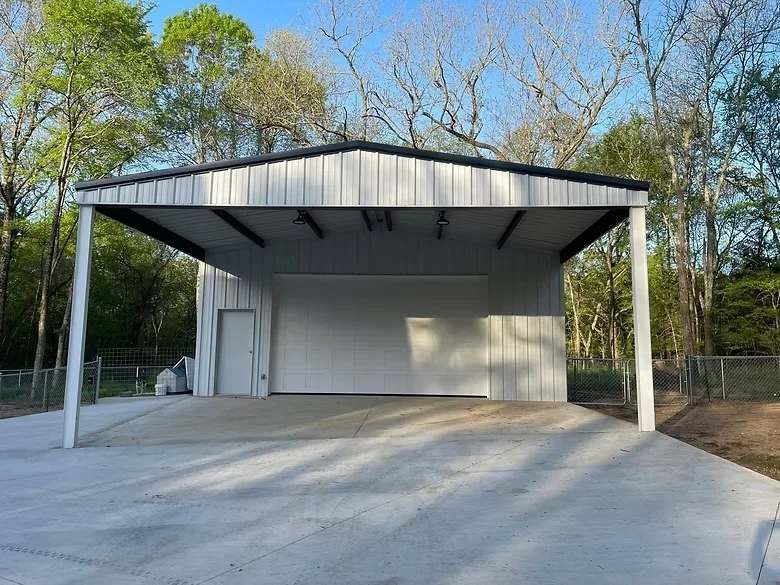 Concrete pad and carport foundation with metal frame and white metal siding