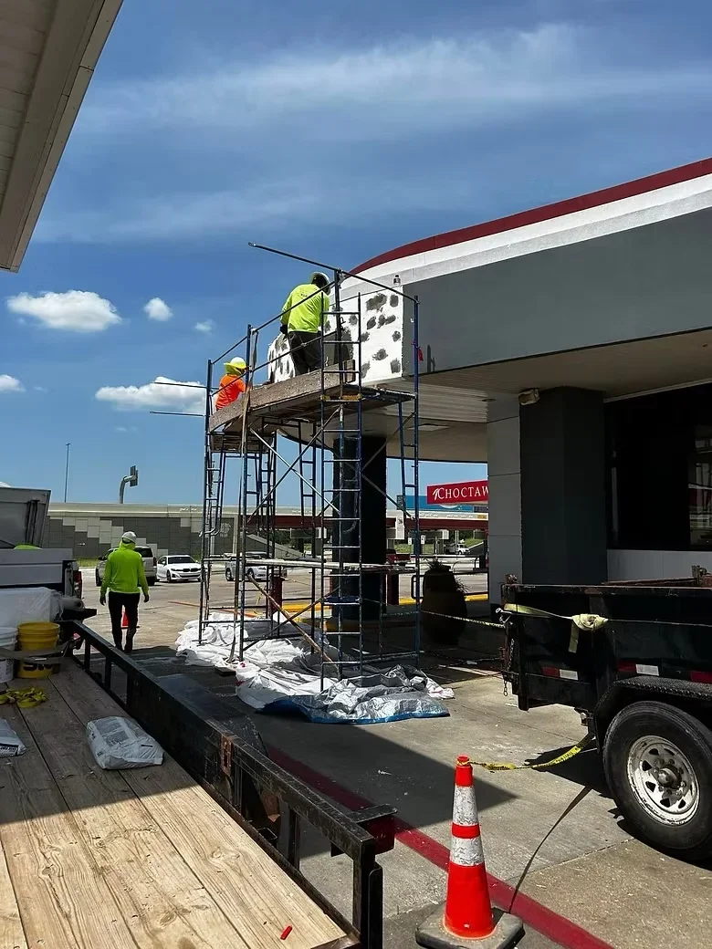 Concrete pad installation with metal scaffolding at commercial storefront entrance