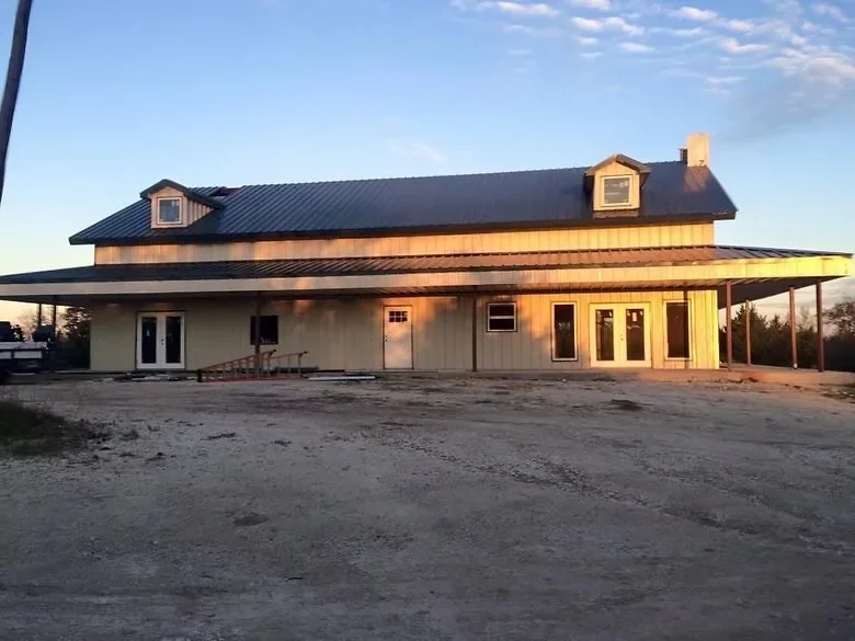 Metal standing seam roof and siding on residential building with dormers and covered porch