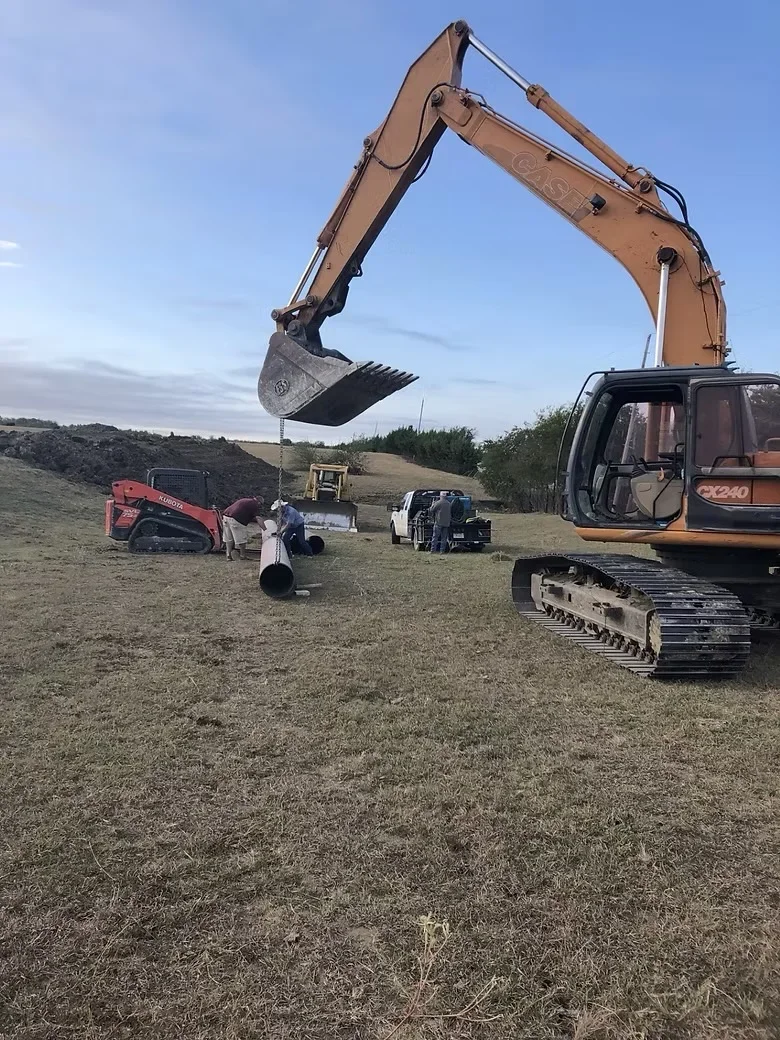 Tracked excavator with bucket attachment and compact track loader on prepared dirt site