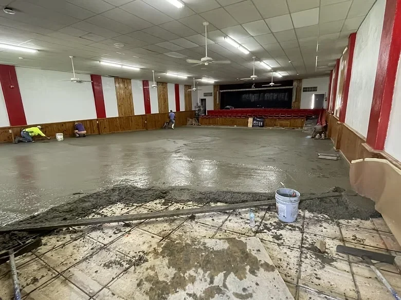 Freshly poured concrete floor with rebar reinforcement in commercial multipurpose space