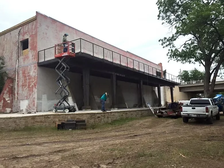Industrial concrete foundation with columns and metal railings under construction