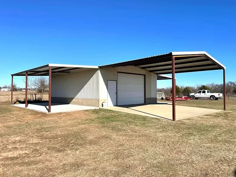 Metal carport with red steel frame, corrugated roof, and concrete pad with attached garage shelter