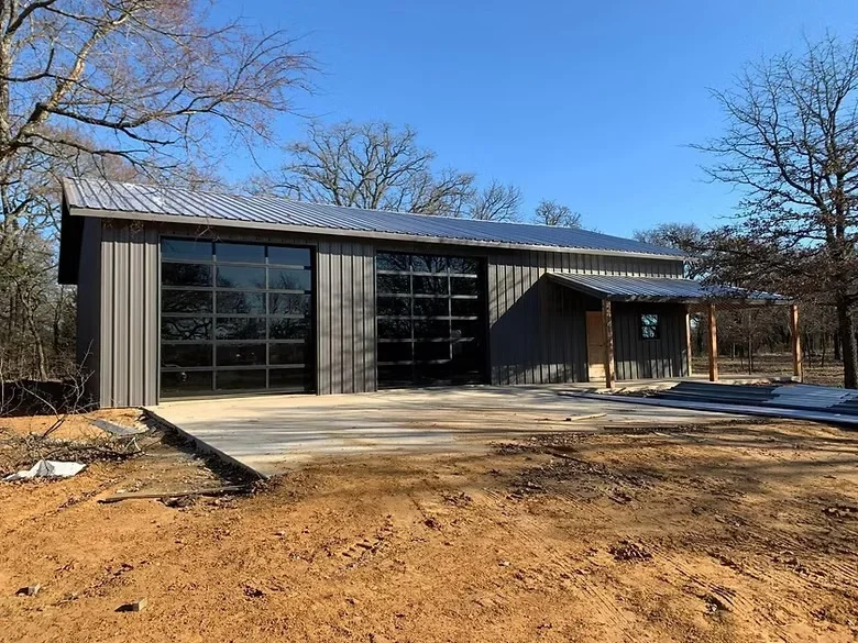 Concrete pad foundation for metal building with corrugated siding and large windows